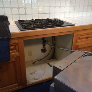 removed old cooktop and oven to cut tile and remove cabinetry for a new wolf freestanding 